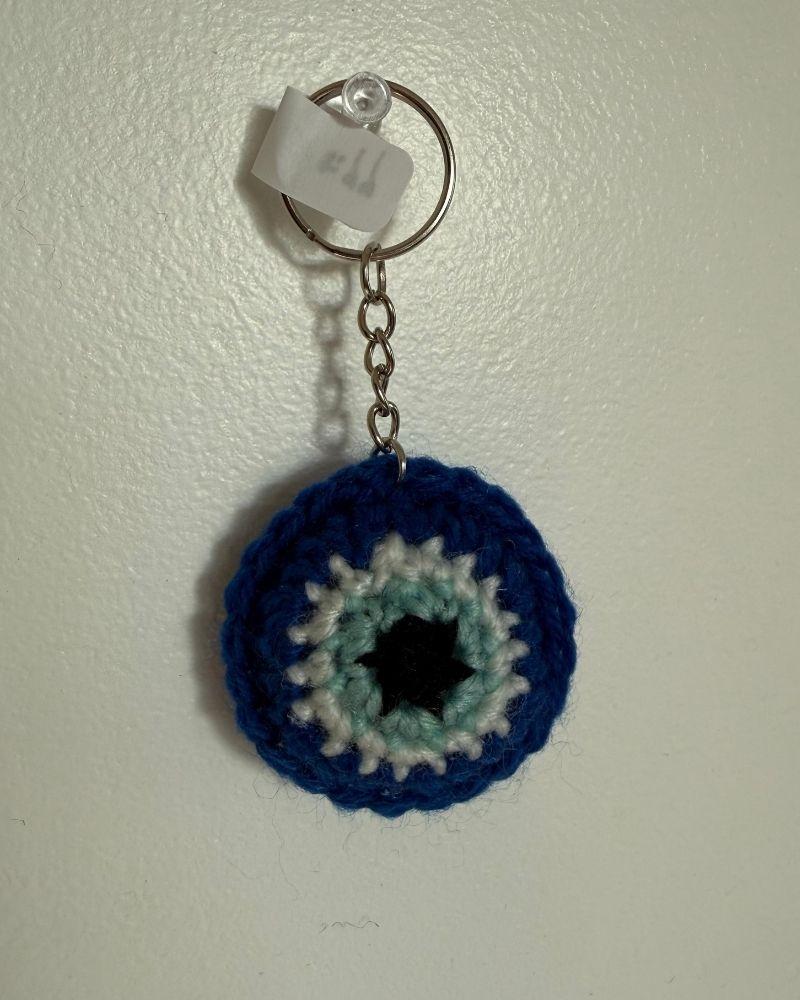 Evil Eye crocheted keychain on a white background