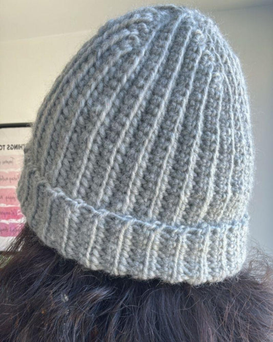 Person wearing a handmade beanie with a leather patch labeled 'Retro Foundry', Gray