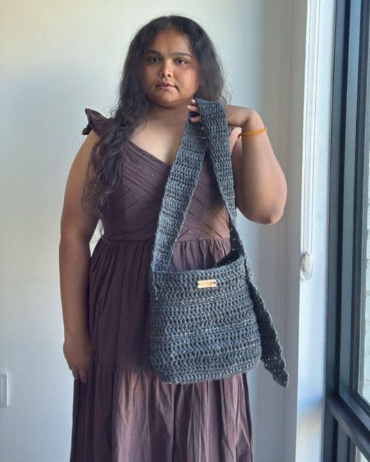 Woman holding a chic crocheted bag indoors, Gray