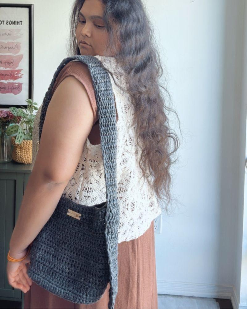 Woman holding a chic crocheted bag indoors, Gray