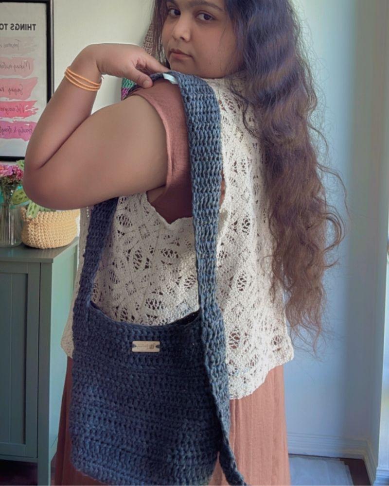Woman holding a chic crocheted bag indoors, Gray