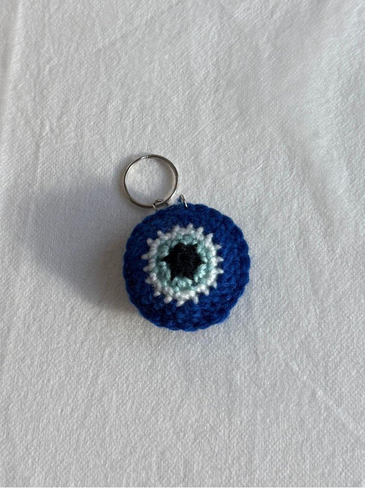 Evil Eye crocheted keychain on a white background