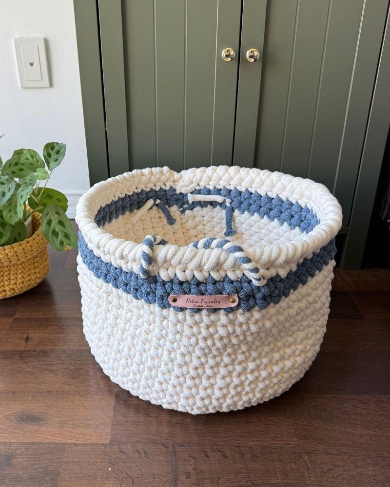 White woven basket on a wooden floor next to a green cabinet, Blue Off White