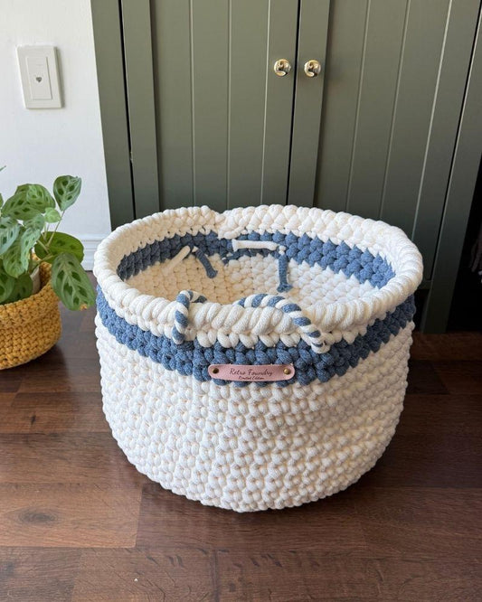 White woven basket on a wooden floor next to a green cabinet, Blue Off White
