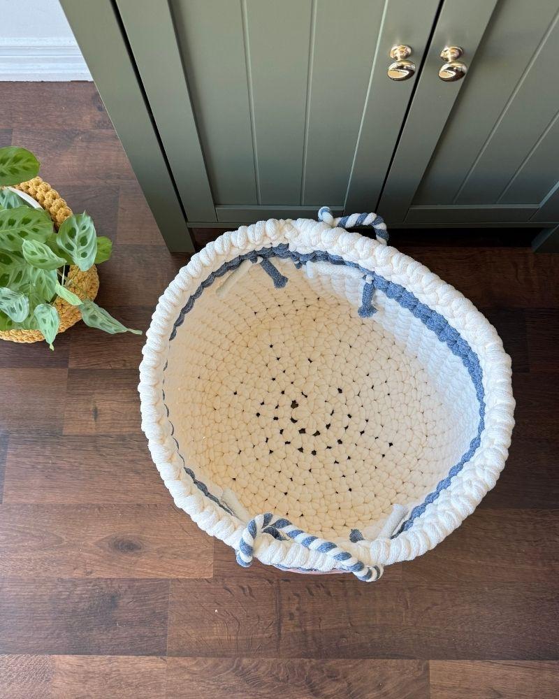 White woven basket on a wooden floor next to a green cabinet, Blue Off White