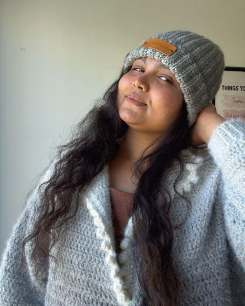 Person wearing a handmade beanie with a leather patch labeled 'Retro Foundry', Gray